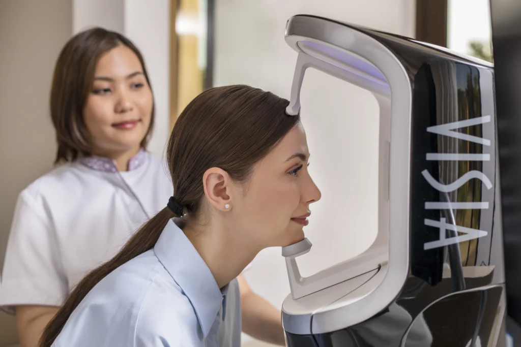 A woman is assessed by wellness treatment equipment.