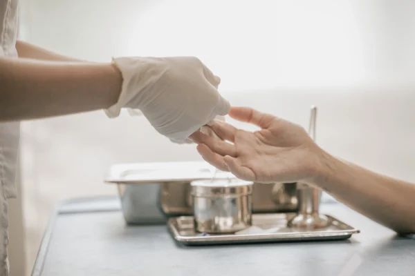 A gloved hand delivers a small vial to another person's hand for Epigenetic testing.